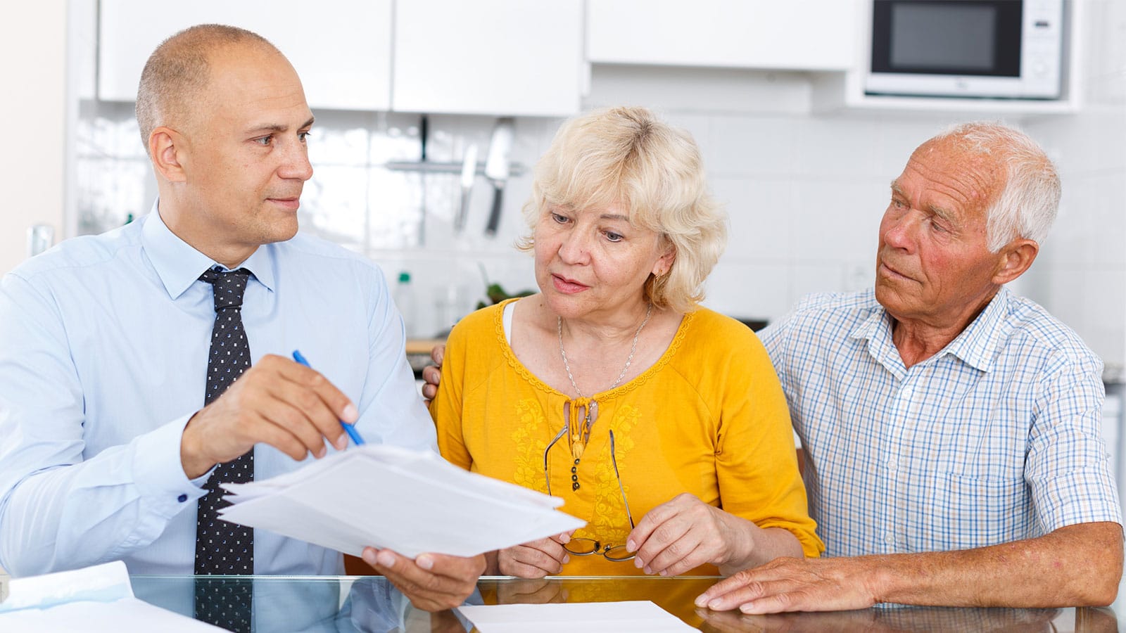 Personal Finance Manager assisting senior couple with their financial organization.
